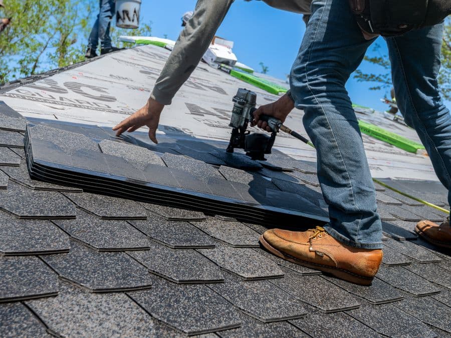 A professional roofer installing shingles on a new roof — local home-service work
